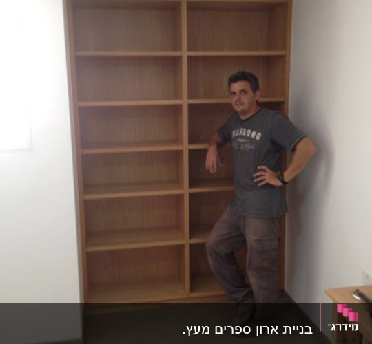 נגר עומד ליד מדף עץ גדול וריק